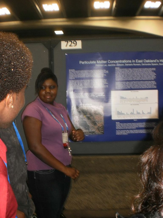 Students at an event standing next to a science poster